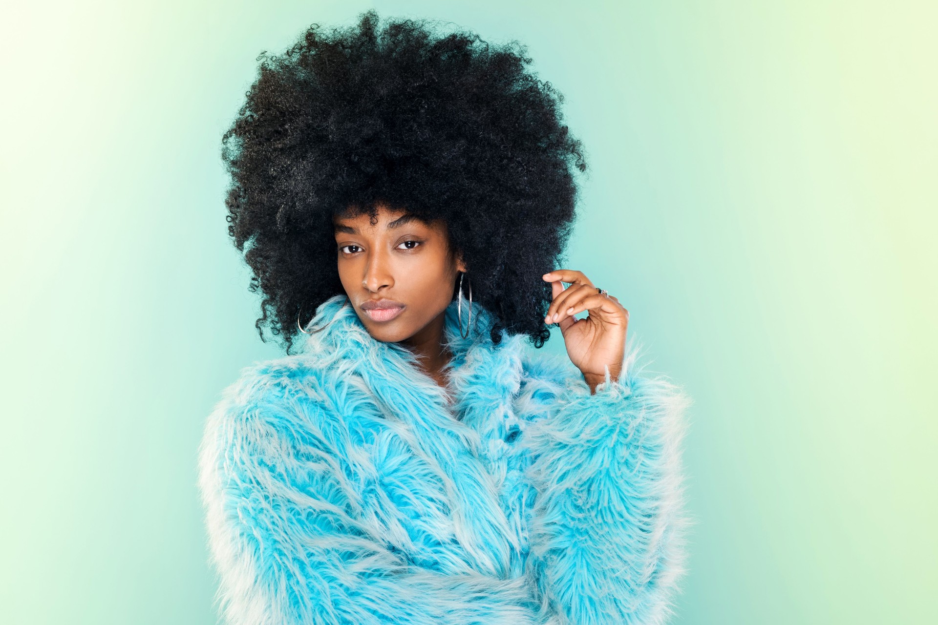 Cute young Black woman wearing a cool blue winter top